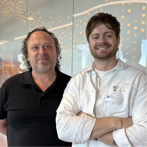 Two Online Marketing Gurus programmatic advertising specialists smiling together in the office.