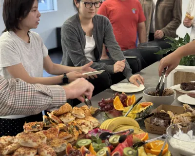 OMG team serving themselves from a breakfast spread in the office