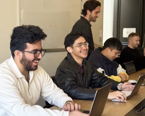 OMG Meta Ads team members working together on laptops during a campaign planning session