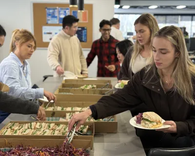 OMG team helping themselves to catered lunch in the office