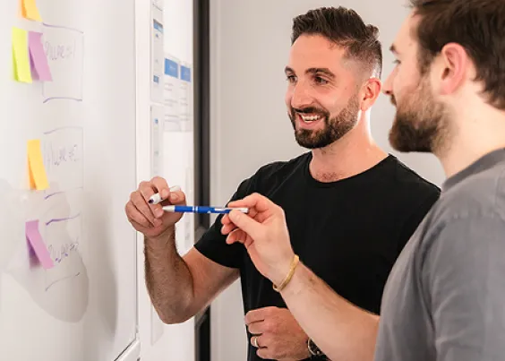 OMG strategists mapping out a client discovery session on a whiteboard
