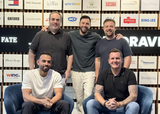 OMG's Australia, US and Dubai leadership team in front of a wall of client brand logos.