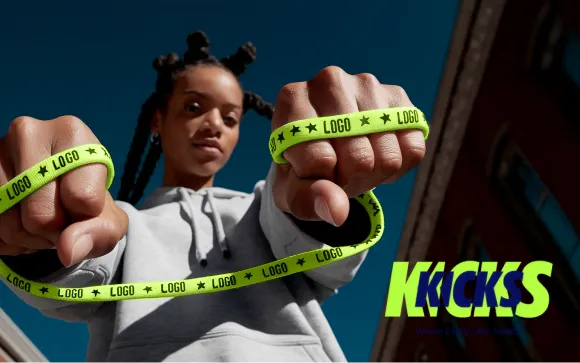 Person holding a neon yellow branded shoelace stretched between both hands against a blue sky