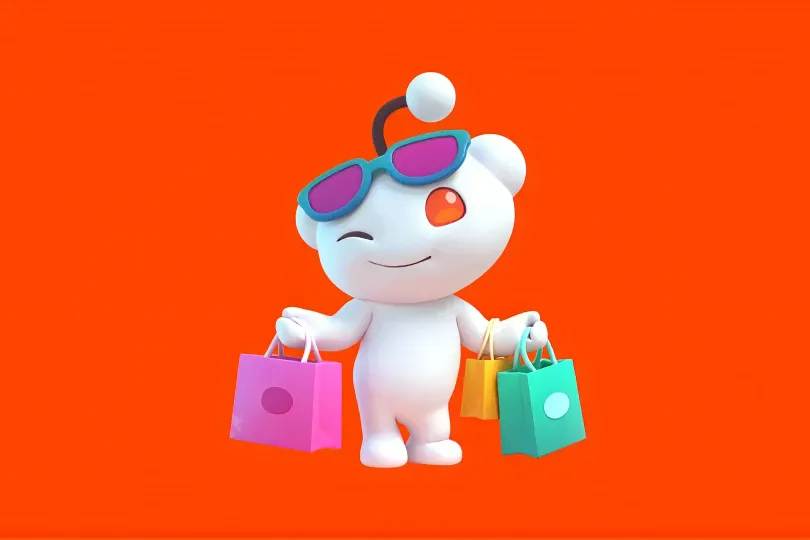 3D Reddit mascot wearing sunglasses and carrying shopping bags