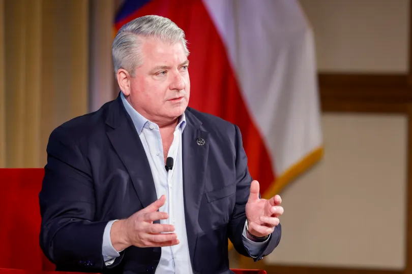 Speaker addressing an audience in front of a Texas flag